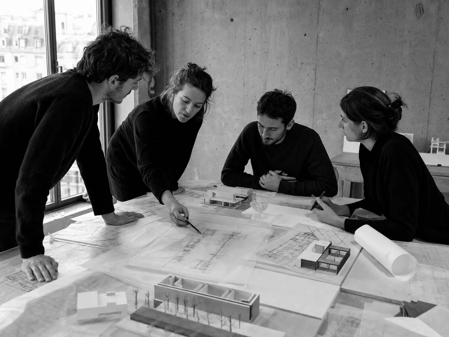 Équipe Arko réunie autour de plans et de maquettes